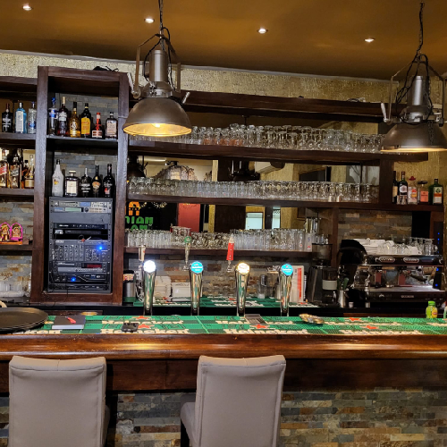 Bar met kranen en glazen bij Indian Naan Restaurant