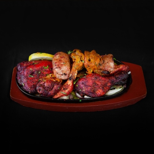 Mixed grill platter with chicken tikka, kebabs, and sausages