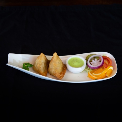 Two samosas with mint chutney and salad
