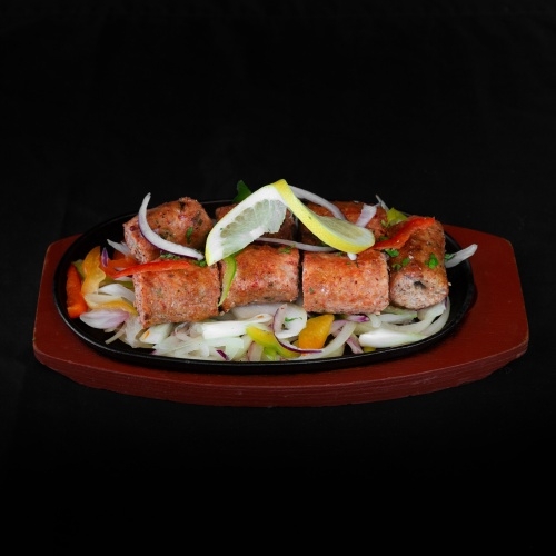 Sizzling seekh kebabs with lemon and onions
